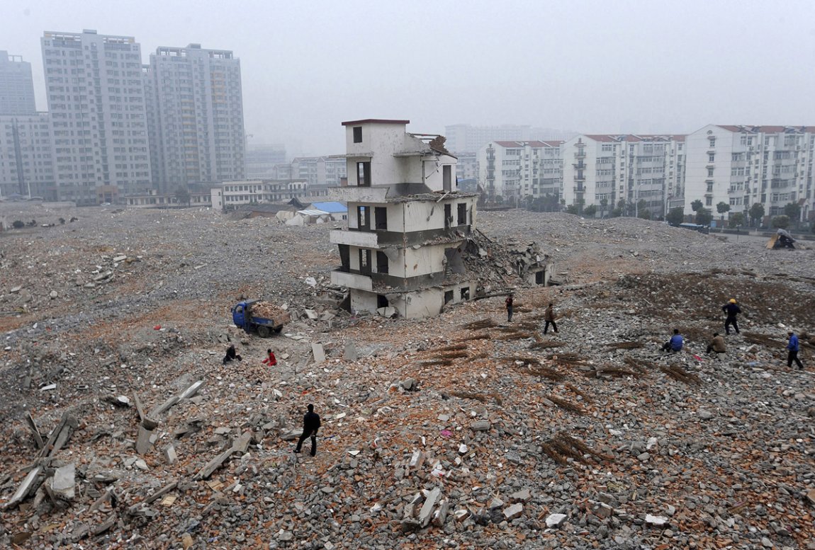 Na fotografiji gradilišta u Hefeji u provinciji Anhui vidi se i je delimično srušena konstrukcija kuće čiji je vlasnik nakon početka rušenja odlučio da traži veću nadoknadu.